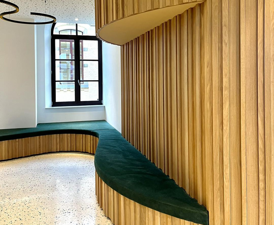 Banquette d'assise en bois avec du velours vert d'un hall entrée